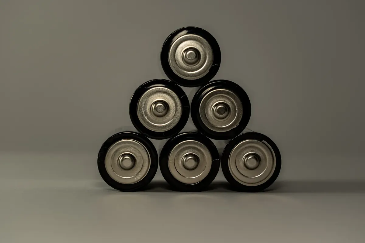 Metallic AA batteries stacked in a pyramid shape, symbolizing power and energy storage.