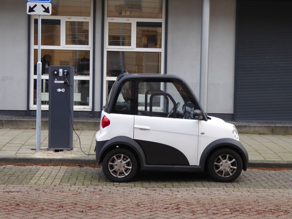 Een moderne elektrische auto die wordt opgeladen bij een laadstation.