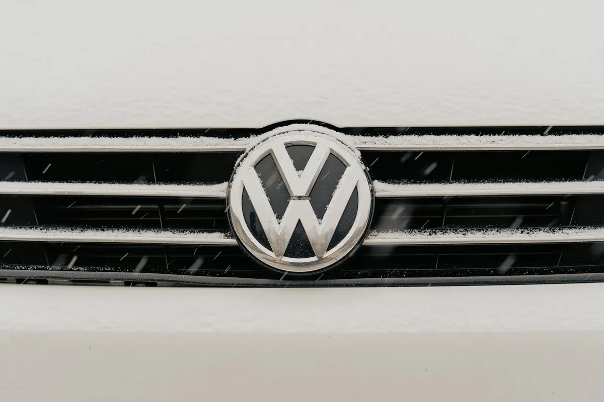 雪が降った Volkswagen のクルマのグリルが特徴的な VW ロゴを示しているクローズアップ。